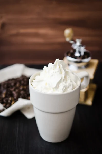 Cup of coffee and a vintage coffee grinder — Stock Photo, Image