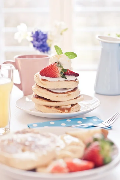 Leckere Pfannkuchen am Frühstückstisch mit Früchten — Stockfoto