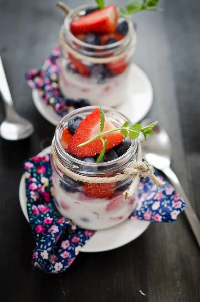 Iogurte de fruto com morangos e mirtilos de perto — Fotografia de Stock
