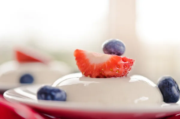 Panna cotta with sauce of blueberries and strawberry closeup — Stock Photo, Image