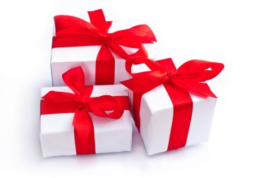 Beyaz hediye kutuları üzerinde beyaz izole kırmızı kurdele ile