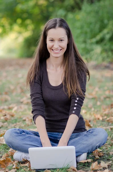 Pretty young smiling womantyping on computer — Stock Photo, Image