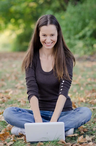 Pretty young smiling womantyping on computer — Stock Photo, Image