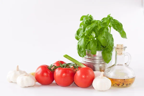 Une bouteille d'huile d'olive épices sur fond blanc avec des légumes — Photo