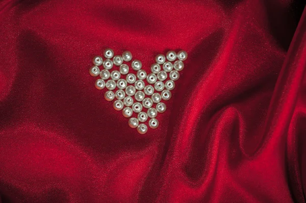 Μαργαριτάρια καρδιά σε ένα κομψό κόκκινο μετάξι για του Αγίου Βαλεντίνου κάρτα — Φωτογραφία Αρχείου