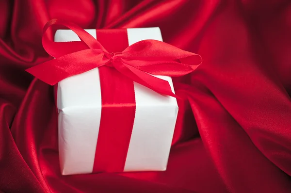 Valentines caixas de presente amarrado com um laço de fita de cetim vermelho no fundo de cetim vermelho — Fotografia de Stock
