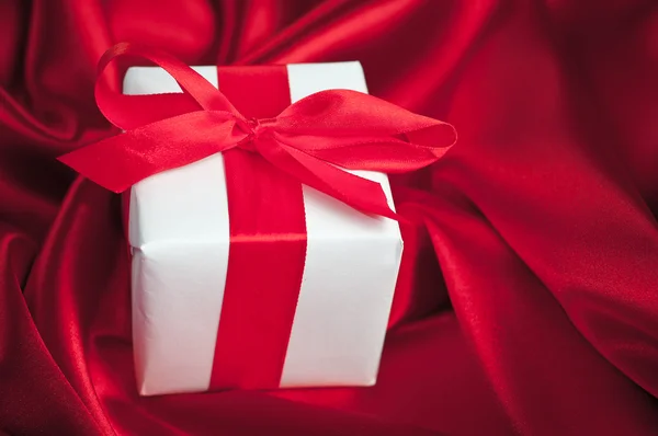 Valentines gift boxes tied with a red satin ribbon bow on red satin background — Stock Photo, Image