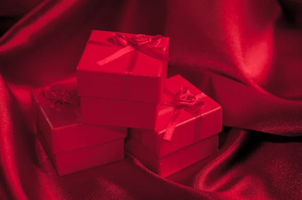 발렌타인 데이 선물 상자 빨간색 새틴 배경에 빨간색 새틴 리본 리본 묶어 — 스톡 사진