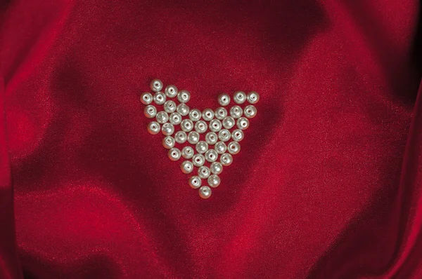 Coeur de perles sur une élégante soie rouge pour carte Saint-Valentin — Photo