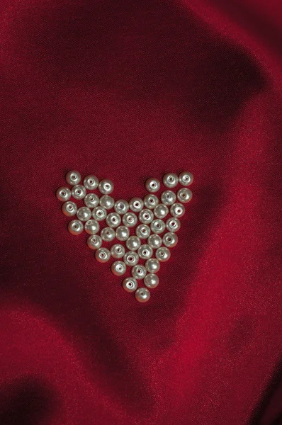 Coeur de perles sur une élégante soie rouge pour carte Saint-Valentin — Photo