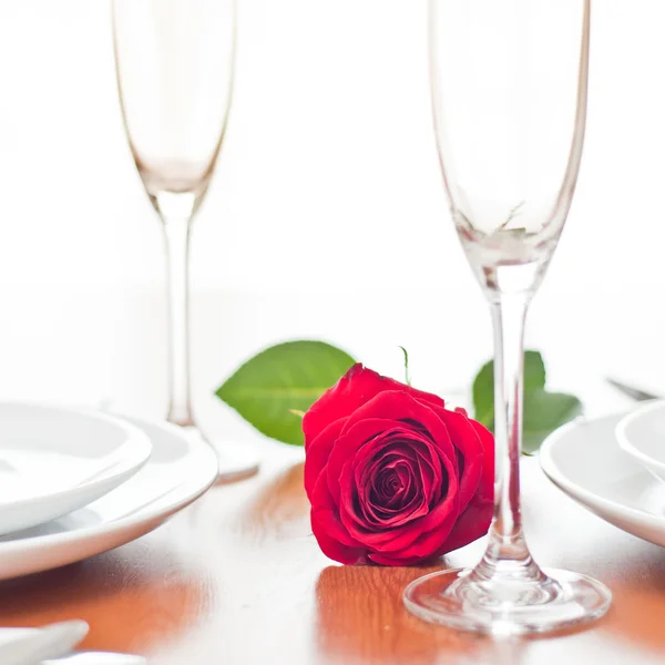 Cena romántica con una rosa y copas de champán —  Fotos de Stock