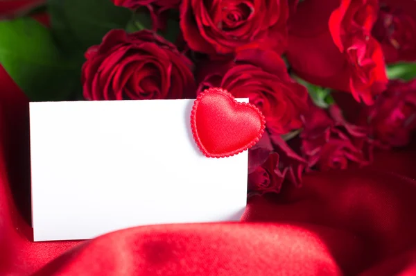 Banda růží s prázdnou kartou za gratulace. — Stock fotografie