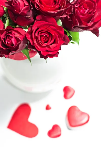 Rosas vermelhas em vaso e doces de chocolate para o Dia dos Namorados — Fotografia de Stock