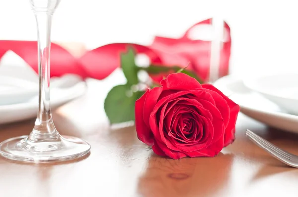 Jantar romântico com uma rosa e taças de champanhe — Fotografia de Stock