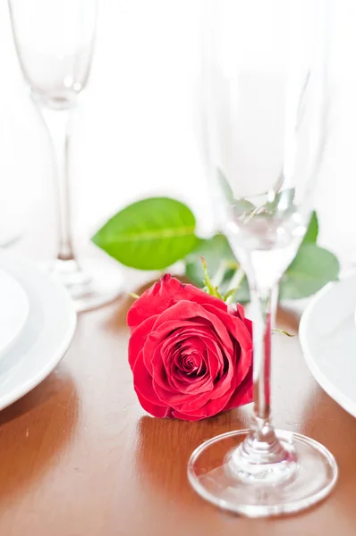 Jantar romântico com uma rosa e taças de champanhe — Fotografia de Stock