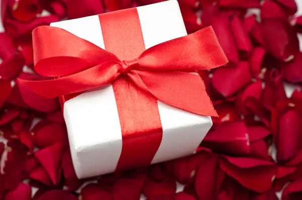 情人节礼品盒带有红色缎面背景上红色缎带蝴蝶结绑 — 图库照片