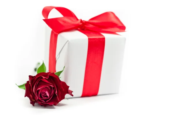 Witte geschenkdoos met rood lint geïsoleerd op wit en rose — Stockfoto