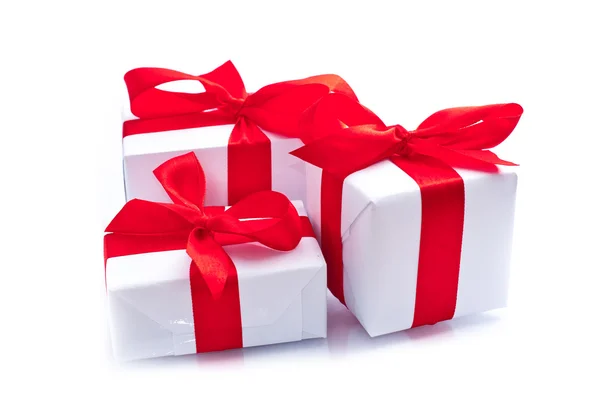 White gift boxes with red ribbon isolated on white — Stock Photo, Image