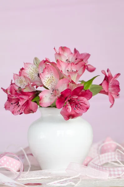 Csokor rózsaszín virágok vázában, rózsaszín háttérrel elszigetelt — Stock Fotó