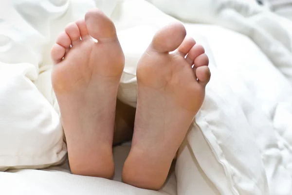 Piedi sotto una coperta bianca — Foto Stock