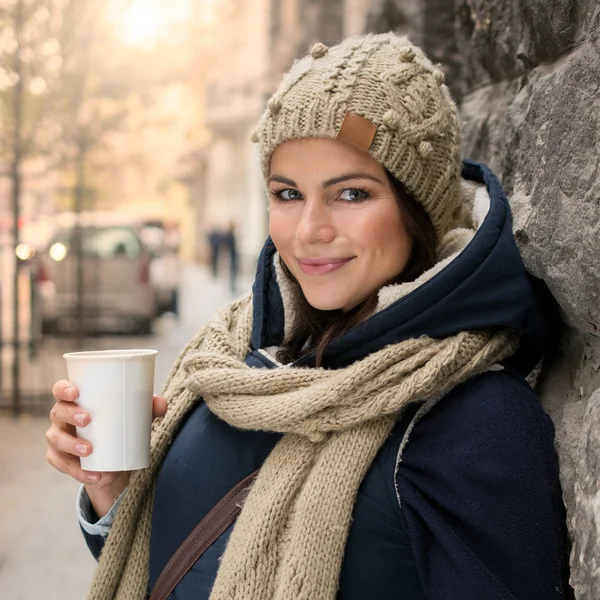 Hermosa mujer bebiendo bebidas calientes en la ciudad — Foto de Stock