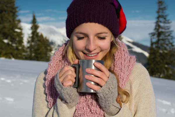 Девушка пьет горячий чай в зимнем лесу — стоковое фото