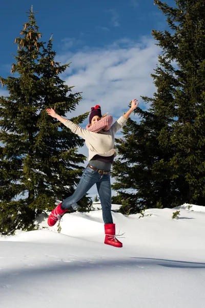 Photo de jolie fille sautant sur les montagnes enneigées — Photo