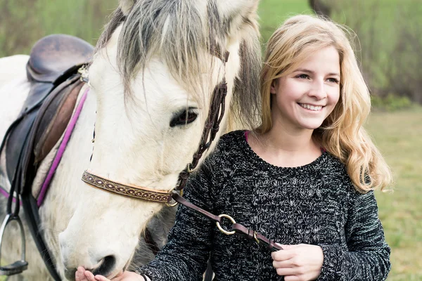 Joven mujer cuidando de su caballo — Foto de Stock