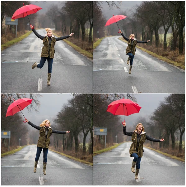 Mujer corriendo y saltando bajo la lluvia con paraguas rojo — Foto de Stock