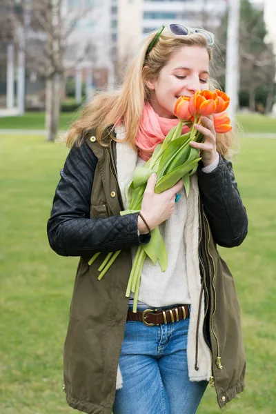 Mladá žena hospodářství tulipány — Stock fotografie