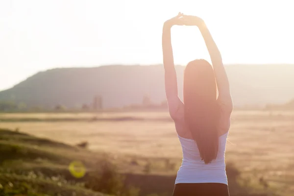 Mulher desfrutando do pôr do sol . — Fotografia de Stock