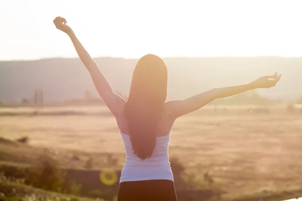 Cheering woman open arms to sunrise — Stock Photo, Image