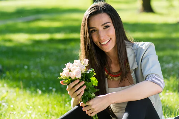 Schöne Frau mit Rosenblüte genießt die Natur — Stockfoto