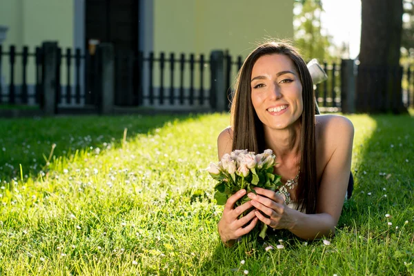 Ung kvinna anläggning rosor — Stockfoto