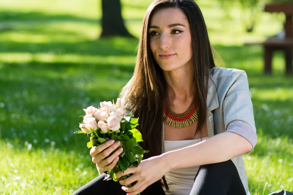 Schöne Frau mit Rosenblüte genießt die Natur — Stockfoto
