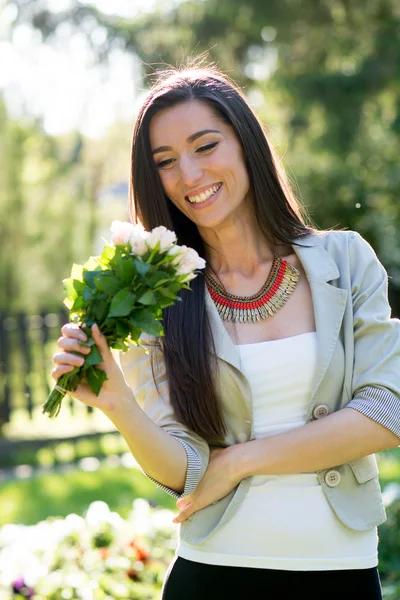 Jovem mulher dando buquê de flores — Fotografia de Stock
