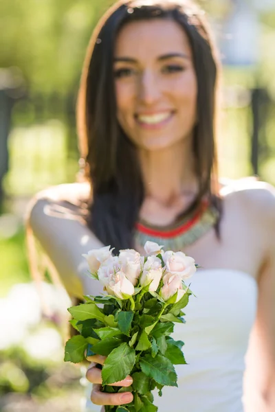 Ung kvinna ger bukett blommor — Stockfoto