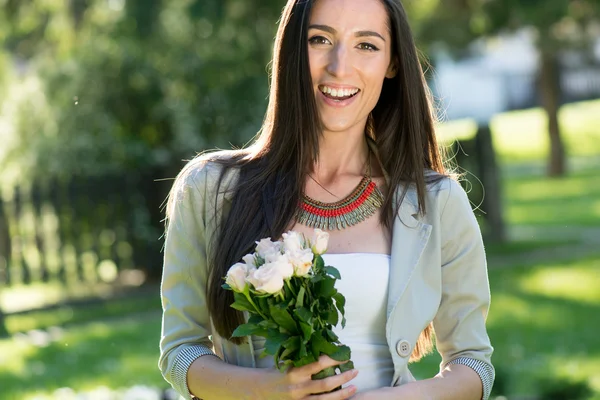 Ung kvinna ger bukett blommor — Stockfoto