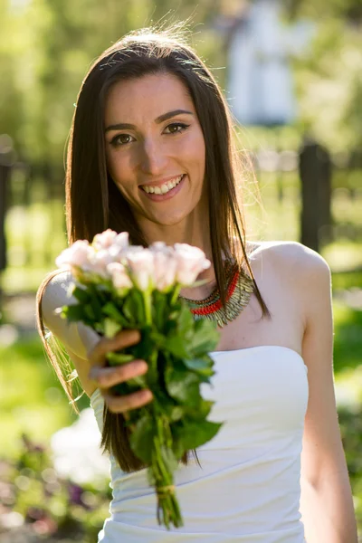 Ung kvinna ger bukett blommor — Stockfoto