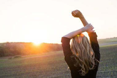 Genç kadın güneş ışınlarını sahiptir