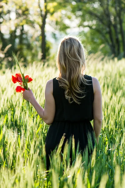 Beautiful blonde dreaming with poppy — Stock Photo, Image