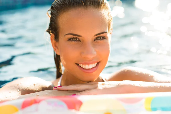 Beauty girl relaxing in pool using mattress — Stock Photo, Image