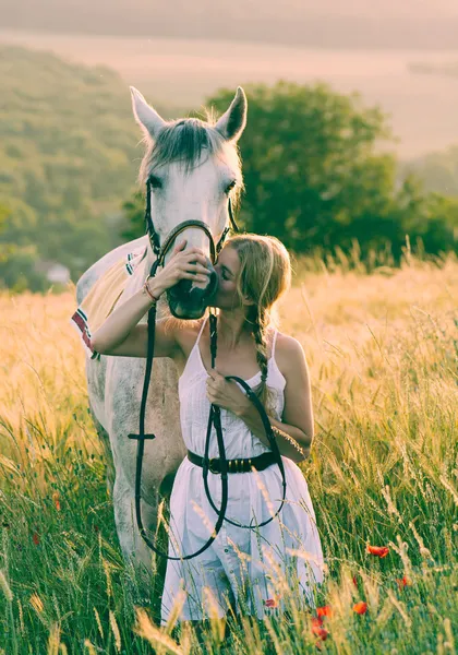 Blonde long hair woman kissing beautiful horse — Stock Photo, Image