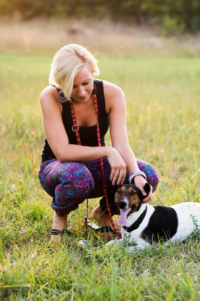 Porträtt av en kvinna med hennes vackra hund liggande utomhus — Stockfoto