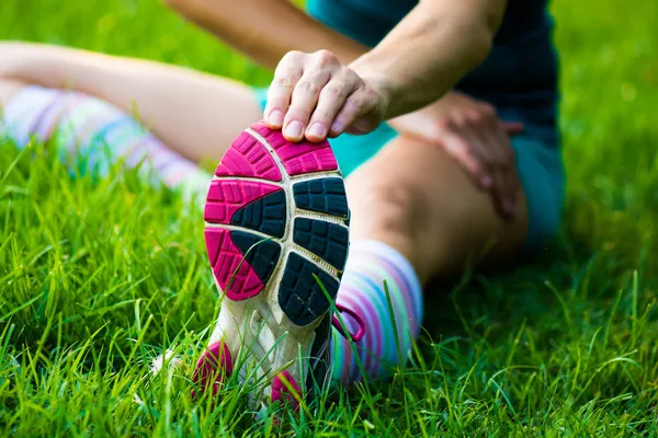 Fitt chica llegar streching su piernas antes de correr al aire libre — Foto de Stock