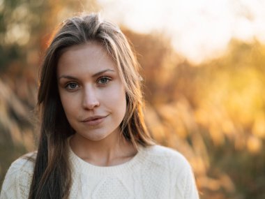 Gün batımında genç bir kızın açık hava portresi.