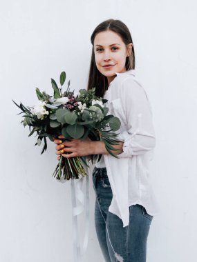 Bir buket çiçekli mutlu çiçekçi kız