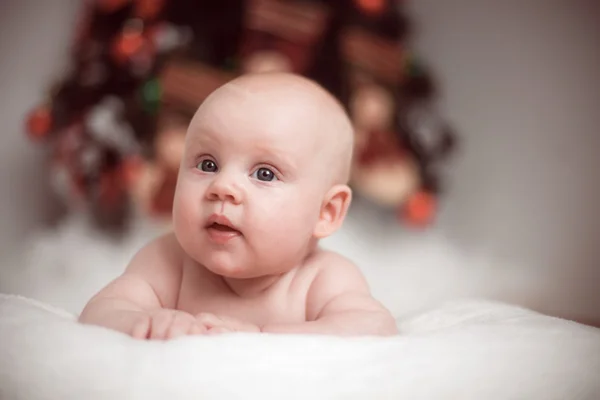クリスマス ツリーの背景に小さな赤ちゃんの肖像画 — ストック写真