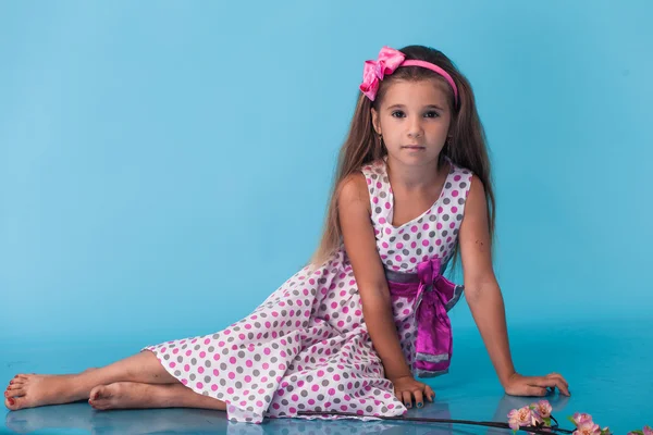 Niedliches kleines Mädchen auf blauem Hintergrund — Stockfoto