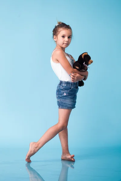 Schattig klein meisje op blauwe achtergrond — Stockfoto